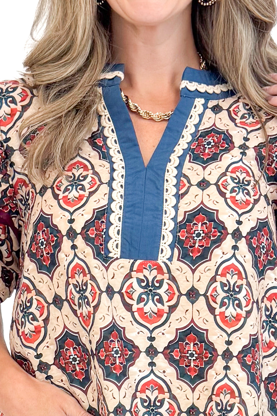 Detailed view of woman wearing Teal and Wine Printed V-neck Top with white background.