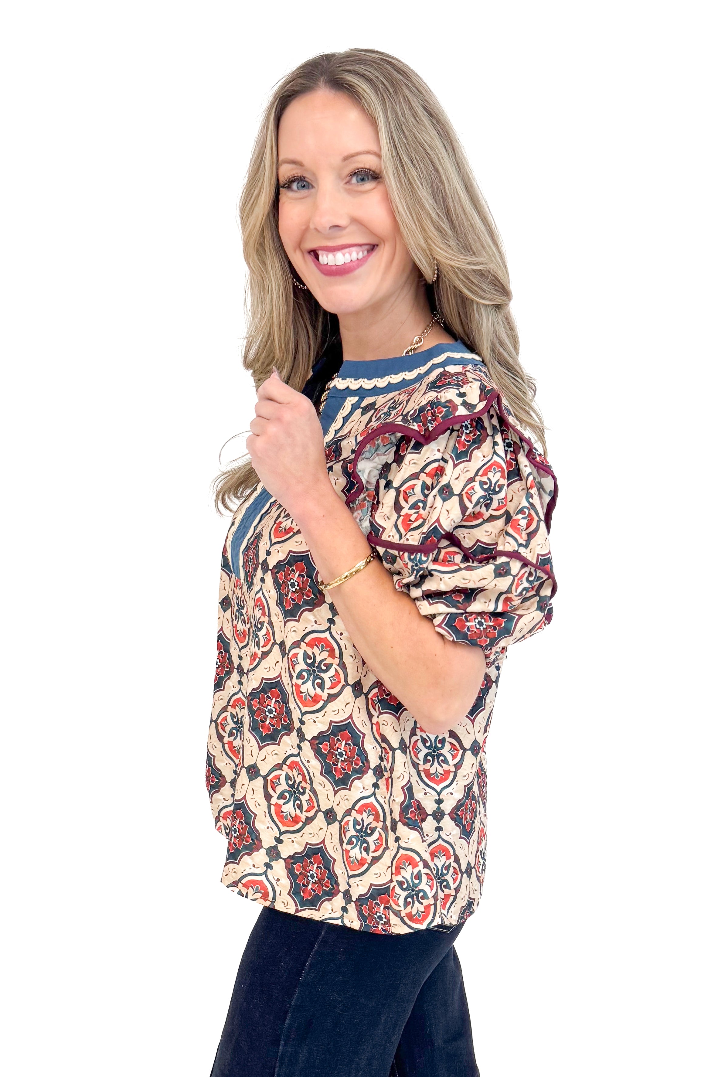 Side view of woman wearing Teal and Wine Printed V-neck Top and jeans with white background.