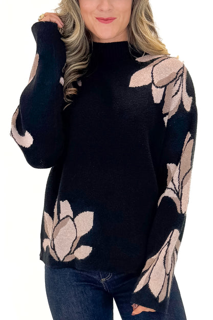 Front detail view of woman wearing Black With Mauve Floral Print Sweater with jeans against white studio background.