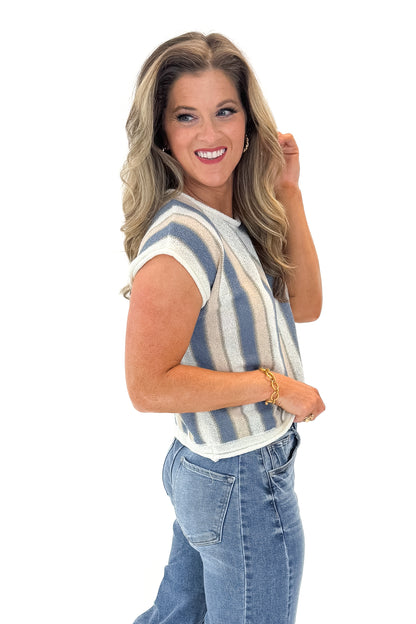 Side view of woman wearing Blue &amp; Tan Striped Short Sleeve Sweater with jeans against white studio background.