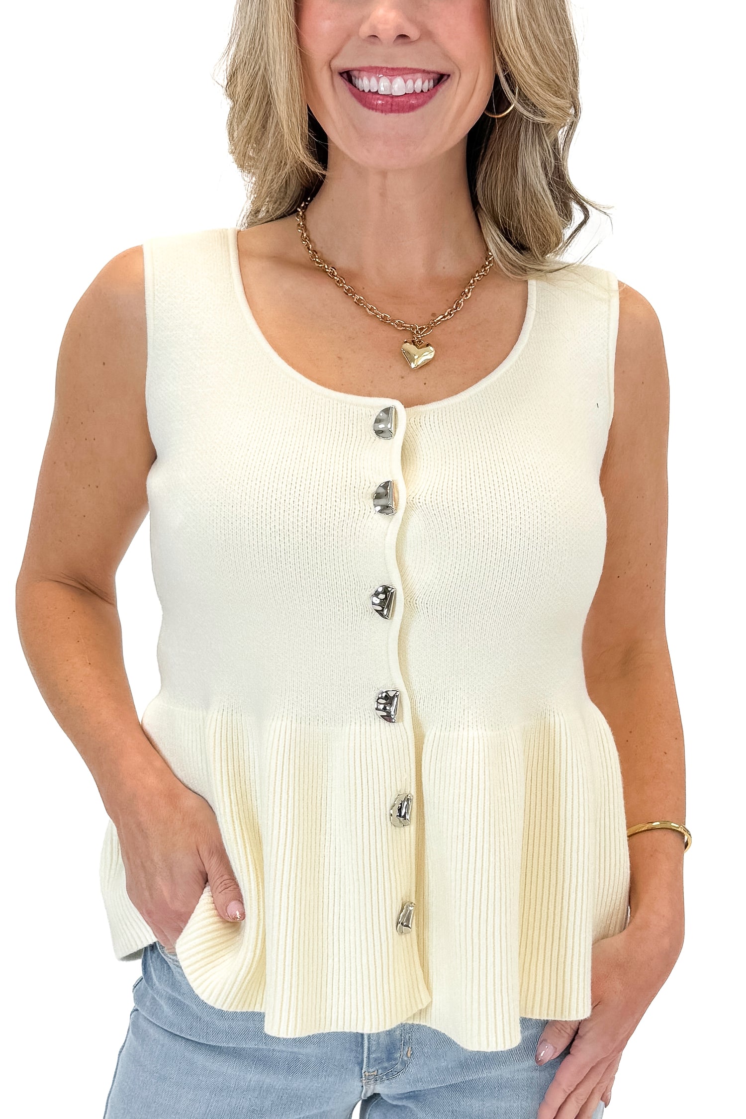 Front detail view of woman wearing Cream Peplum Sweater Tank with jeans against white studio background.