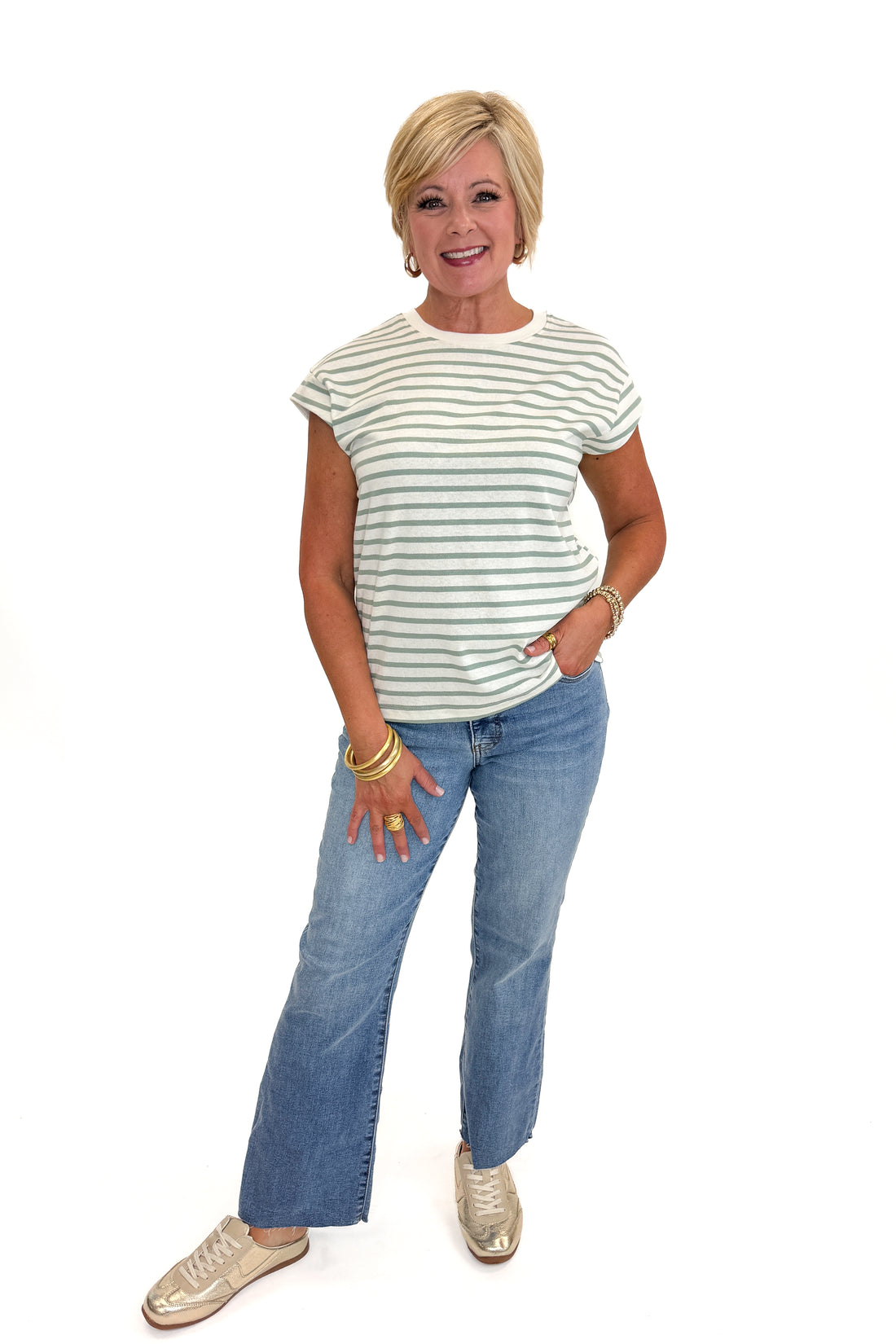 Front view of woman wearing Swagger Boutique’s Sage &amp; Cream Stripe Cap Sleeve Tee with jeans against white studio background.