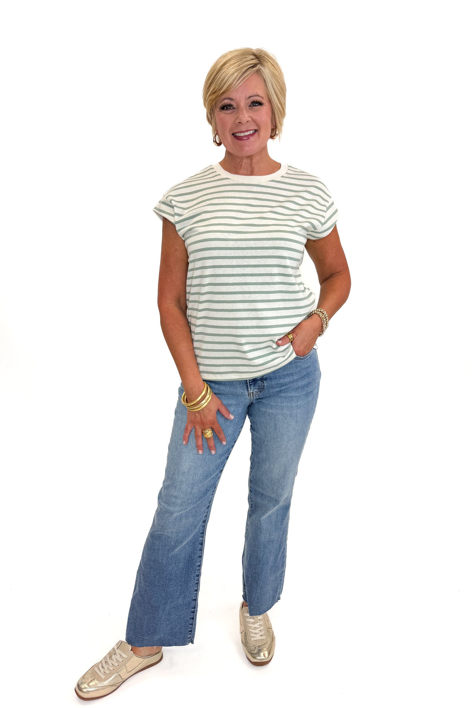 Front view of woman wearing Swagger Boutique’s Sage &amp; Cream Stripe Cap Sleeve Tee with jeans against white studio background.