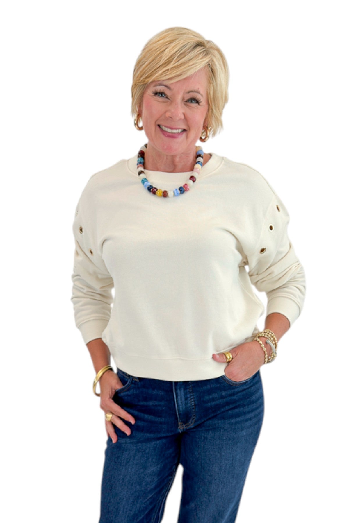 Front view of woman wearing Swagger Boutique’s Sandstone Axel Grommet Sweatshirt by Z Supply with jeans against white studio background.