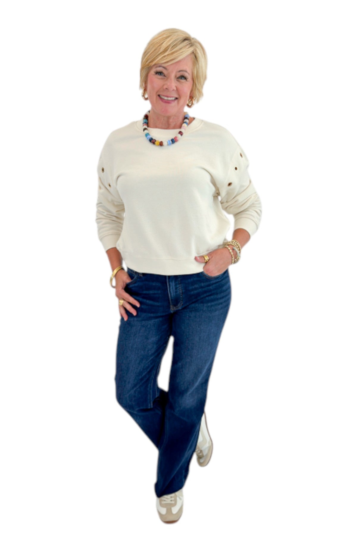 Front view of woman wearing Swagger Boutique’s Sandstone Axel Grommet Sweatshirt by Z Supply with jeans against white studio background.
