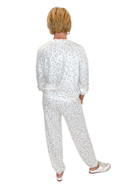 Back view of woman wearing Swagger Boutique’s Sandstone Soft Leo Long Sleeve Top with matching Joggers by Z Supply against white studio background.