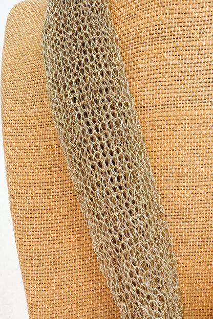 Close-up of a textured chain on a woven beige background