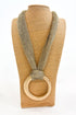 Textured mesh chain with a gold ring on a beige mannequin against a white background