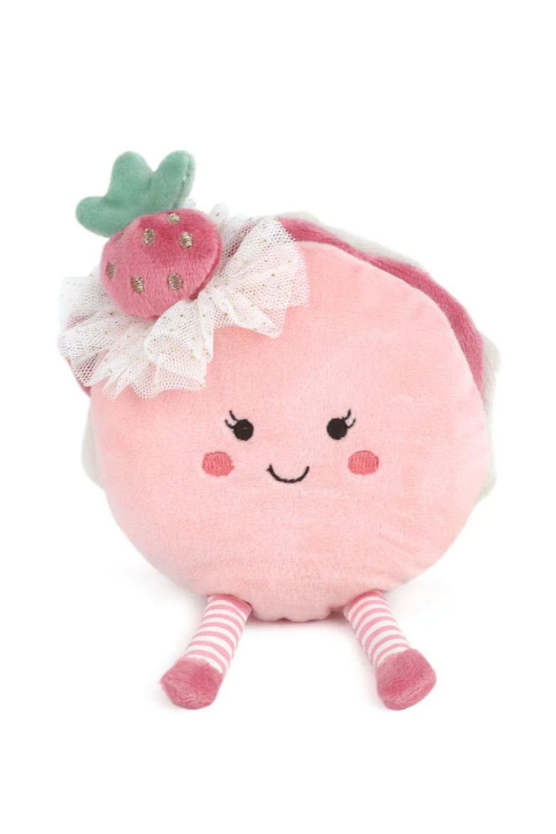 Pink plush toy resembling a macaron with a strawberry on a white background