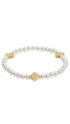Pearl bracelet with a gold cross on a plain white background