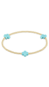 A delicate gold beaded bracelet featuring three turquoise cross charms, displayed on a clean white background.