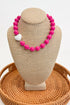Necklace with pink beads and a white heart on a beige bust