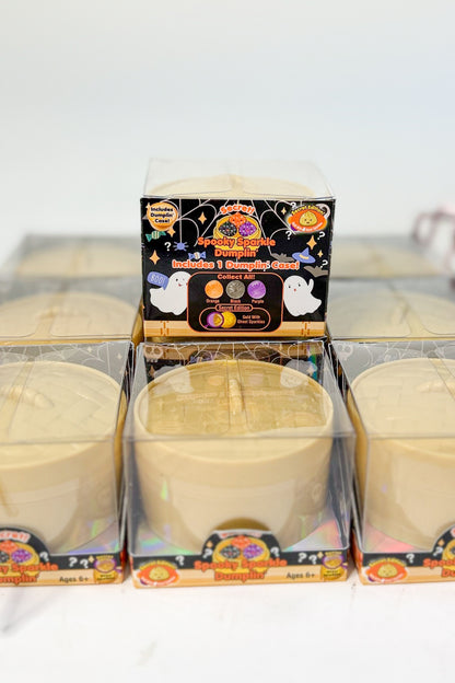 Three unopened packages of dumpling squishies in a grid, with one package standing upright in the center to show the front label.
