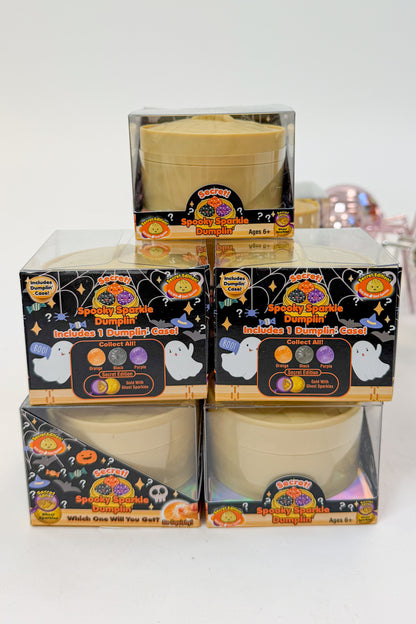 Four Halloween-themed dumpling mystery boxes stacked in a 2x2 grid, with one additional box on top. The packaging features spooky graphics like ghosts, pumpkins, and spiderwebs, and the boxes are clear plastic showing the beige pots inside.