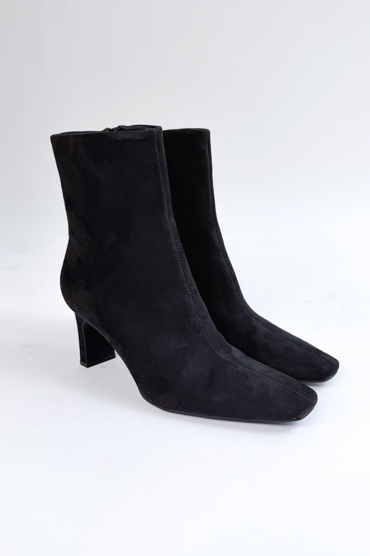 Swan- Black Suede Booties side view against white studio background.