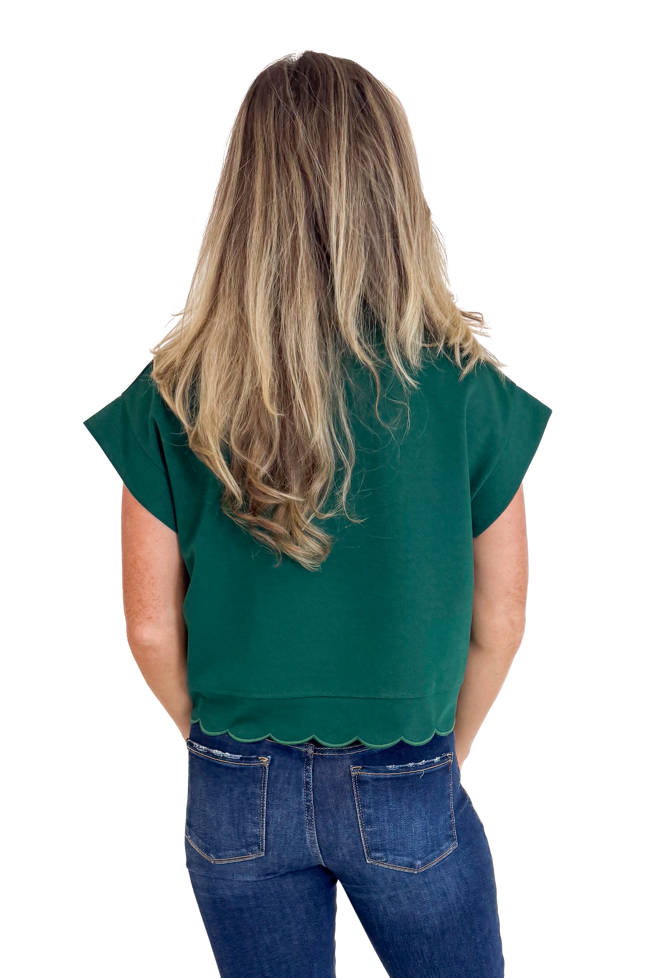 Person wearing a green top and blue jeans on a white background