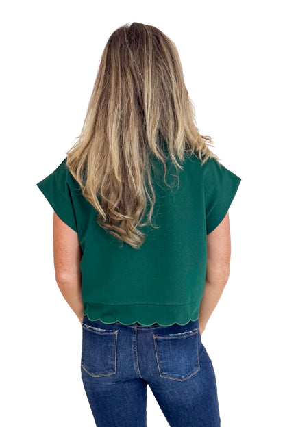 Person wearing a green top and blue jeans on a white background