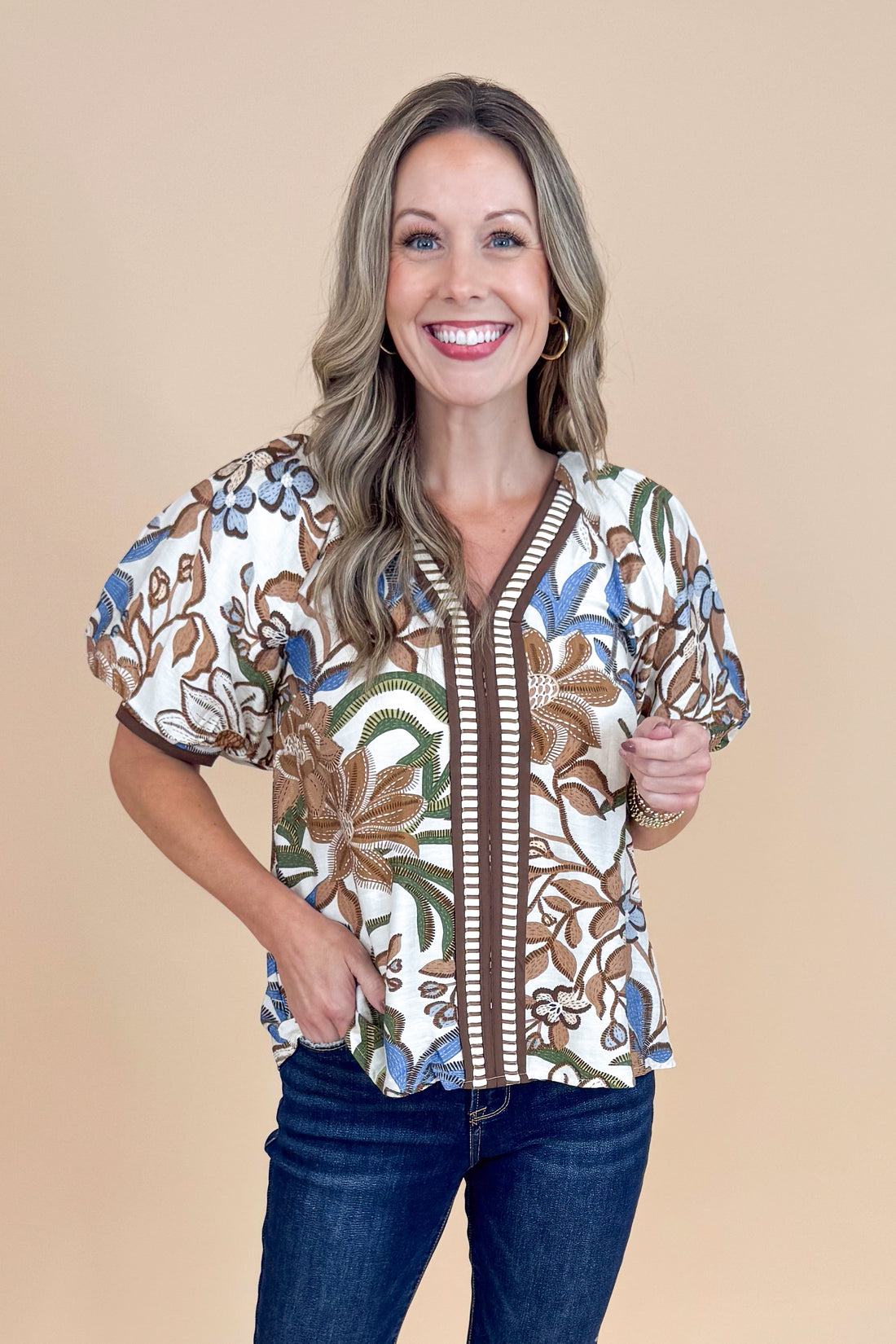 Woman wearing a floral blouse with a beige background