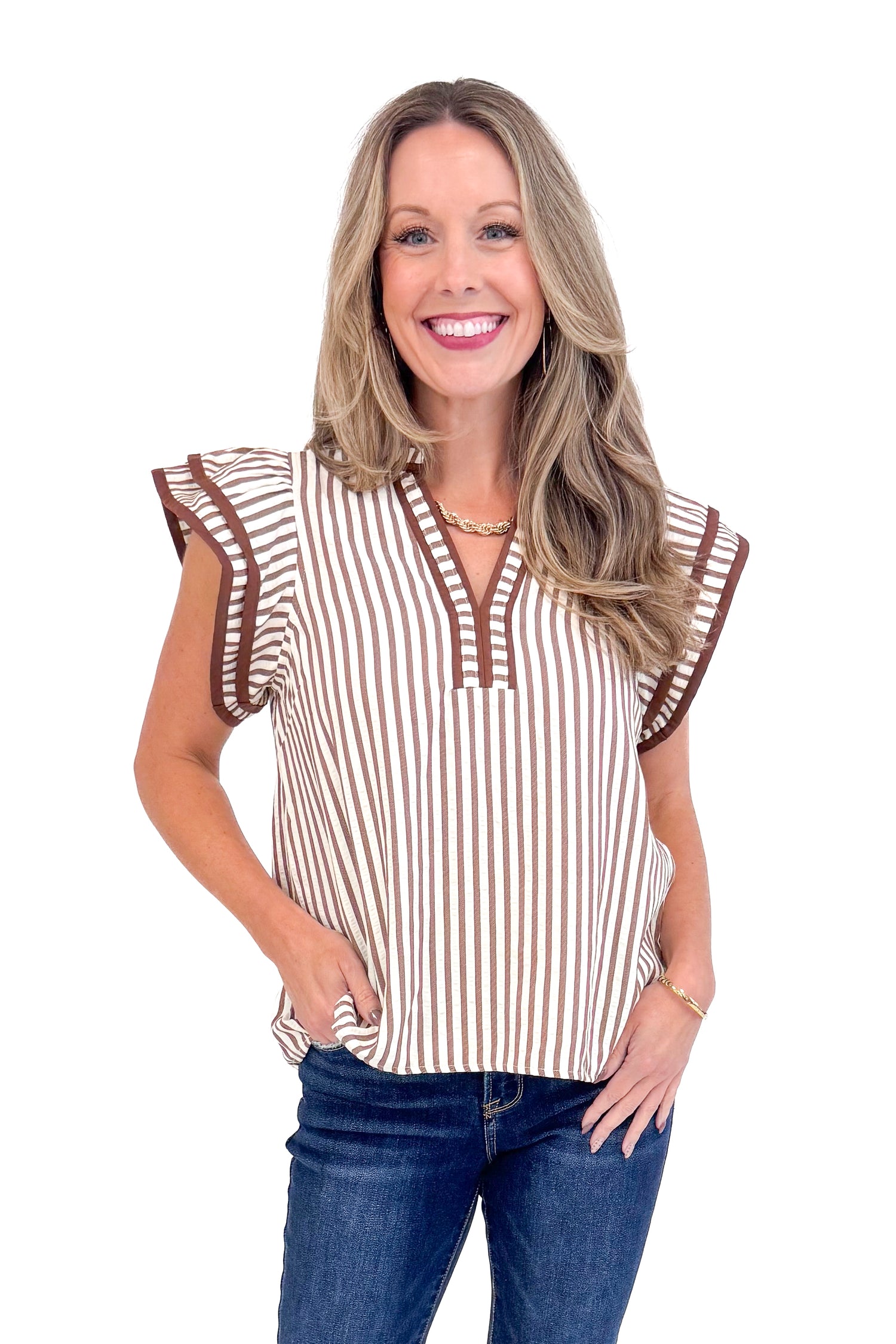 Woman wearing Rise &amp; Shine Brown Striped Flutter Sleeve Top by Entro and jeans against white studio background.