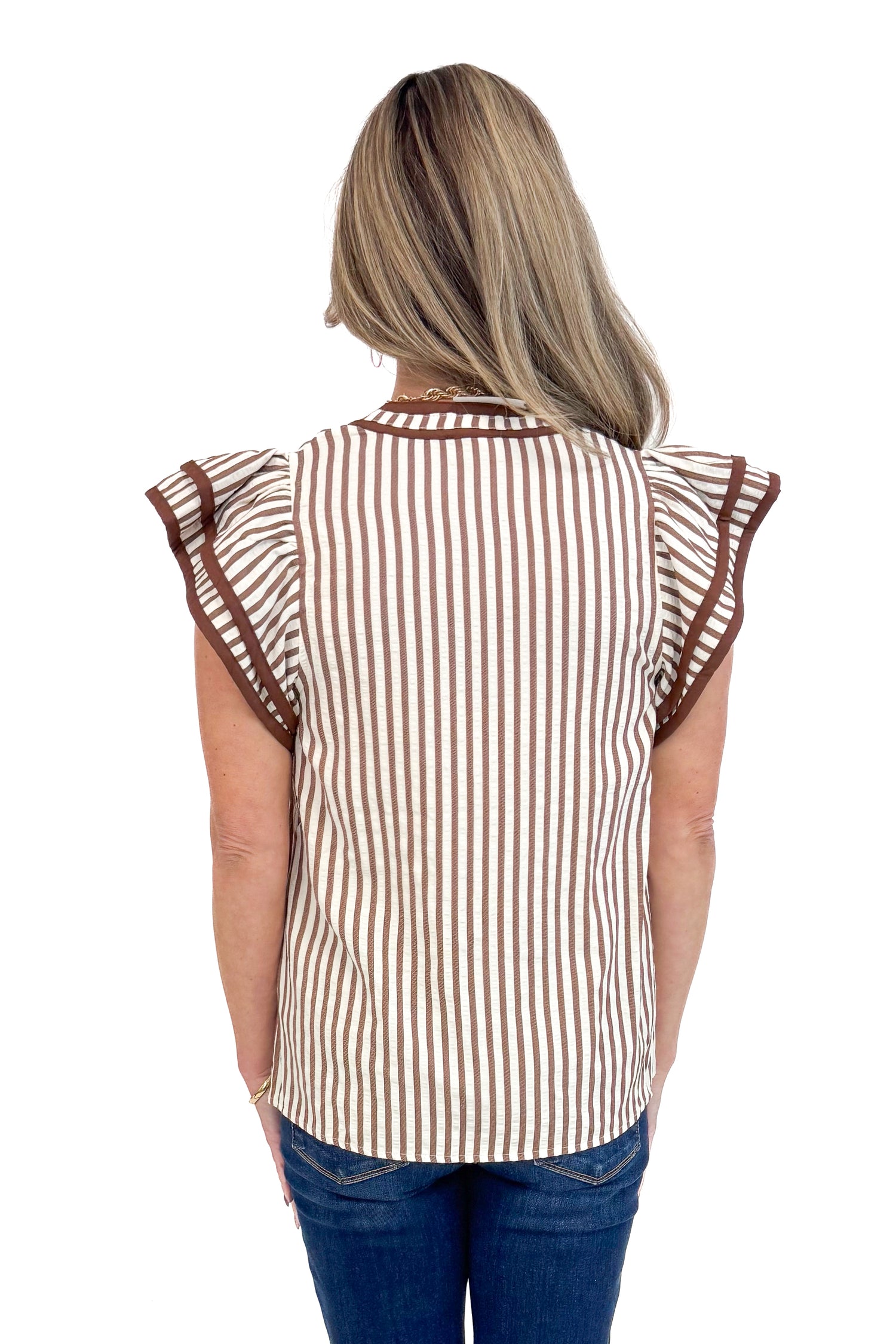 Woman wearing Rise &amp; Shine Brown Striped Flutter Sleeve Top by Entro and jeans against white studio background back view.