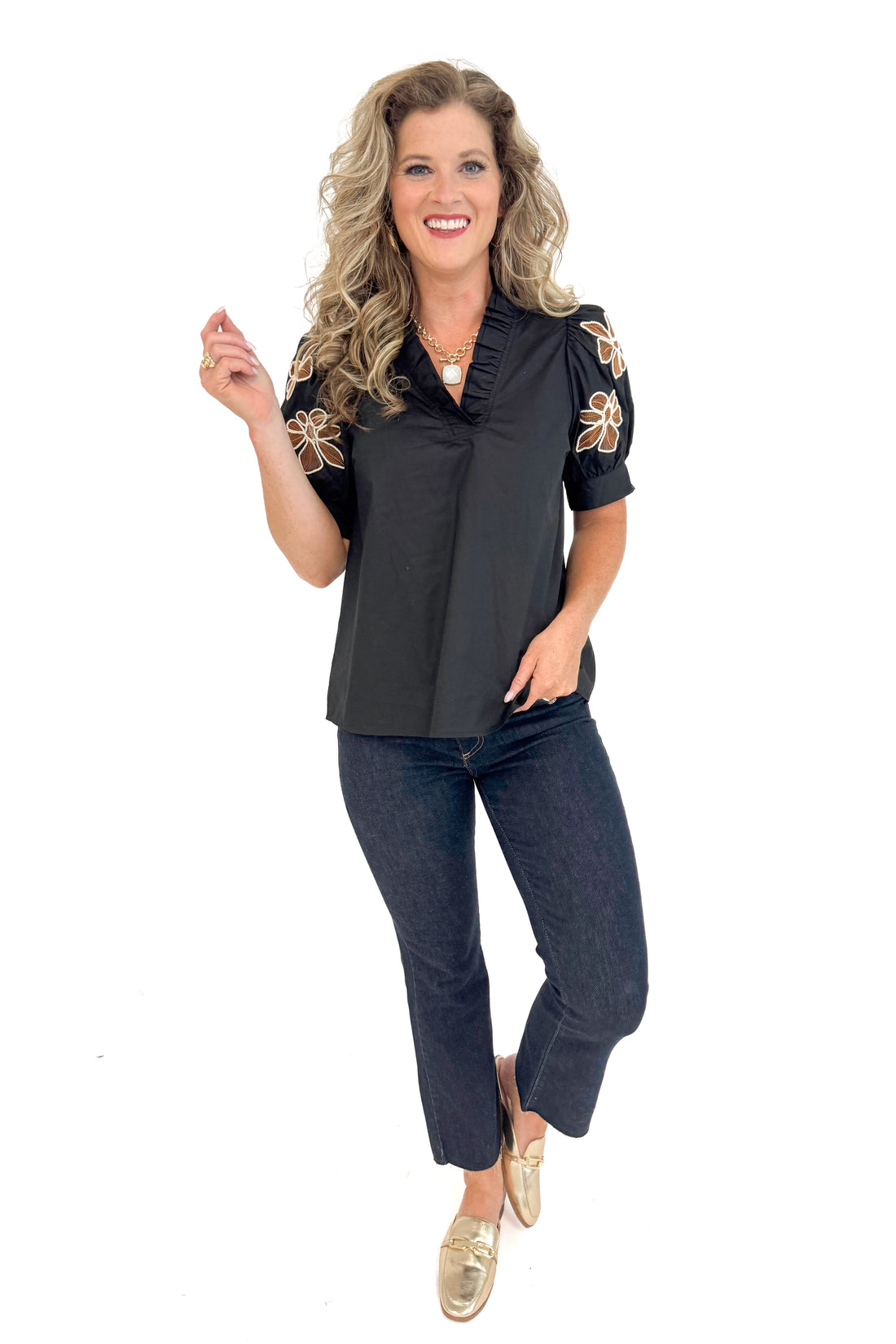 Front view of black short sleeve top showing floral embroidered design.