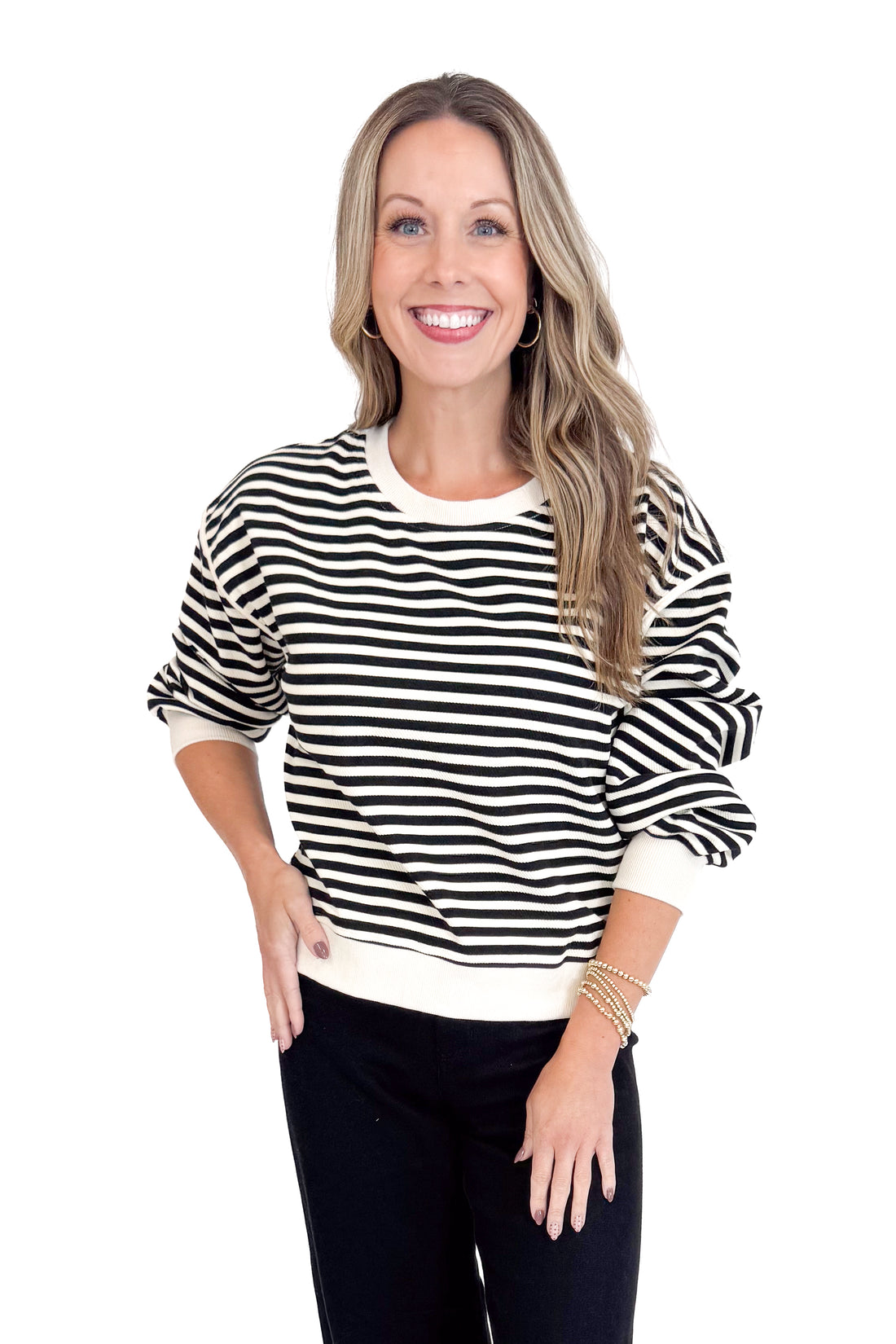 Woman wearing a black and white striped sweater on a white background