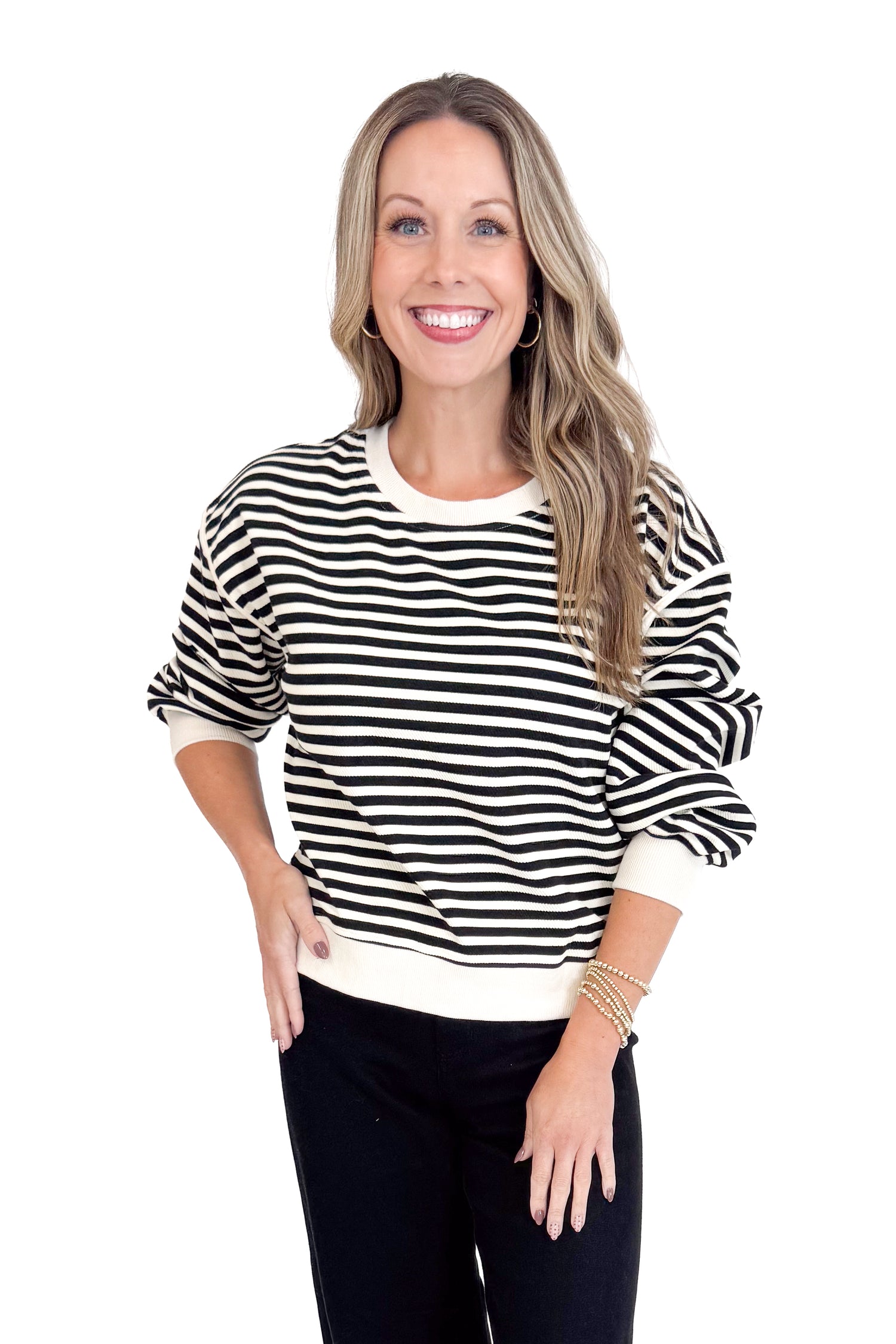 Woman wearing a black and white striped sweater on a white background