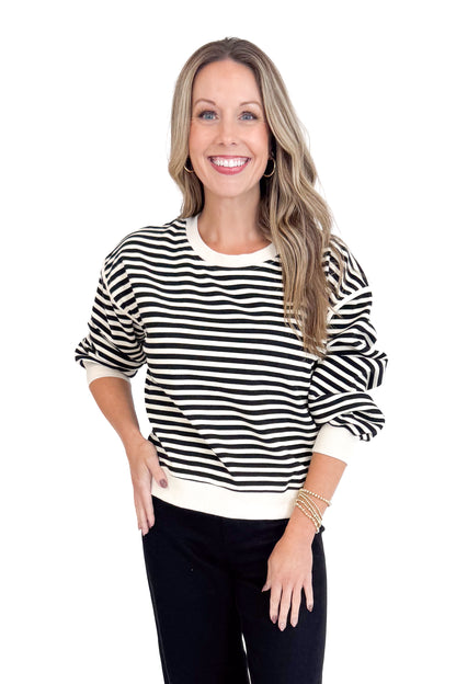 Woman wearing a black and white striped sweater on a white background