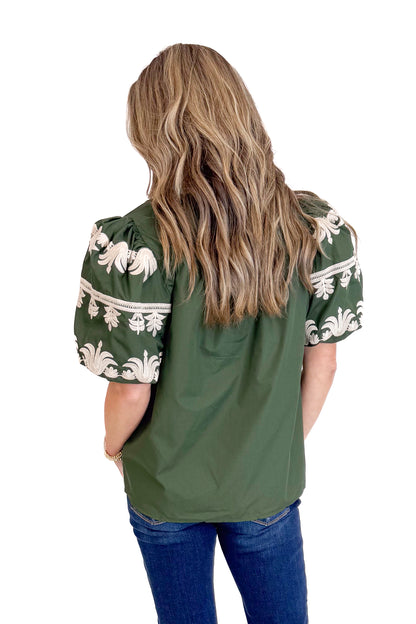 Green blouse with white floral patterns on a white background
