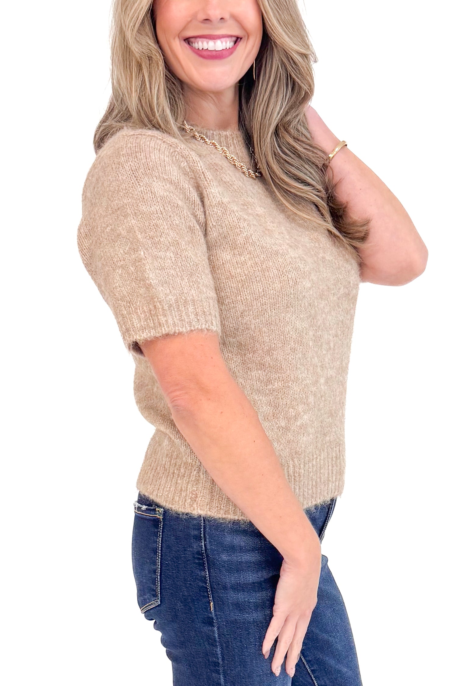 Side view of woman wearing Mocha Short Sleeve Fuzzy Sweater by Entro and blue jeans with white studio background. 