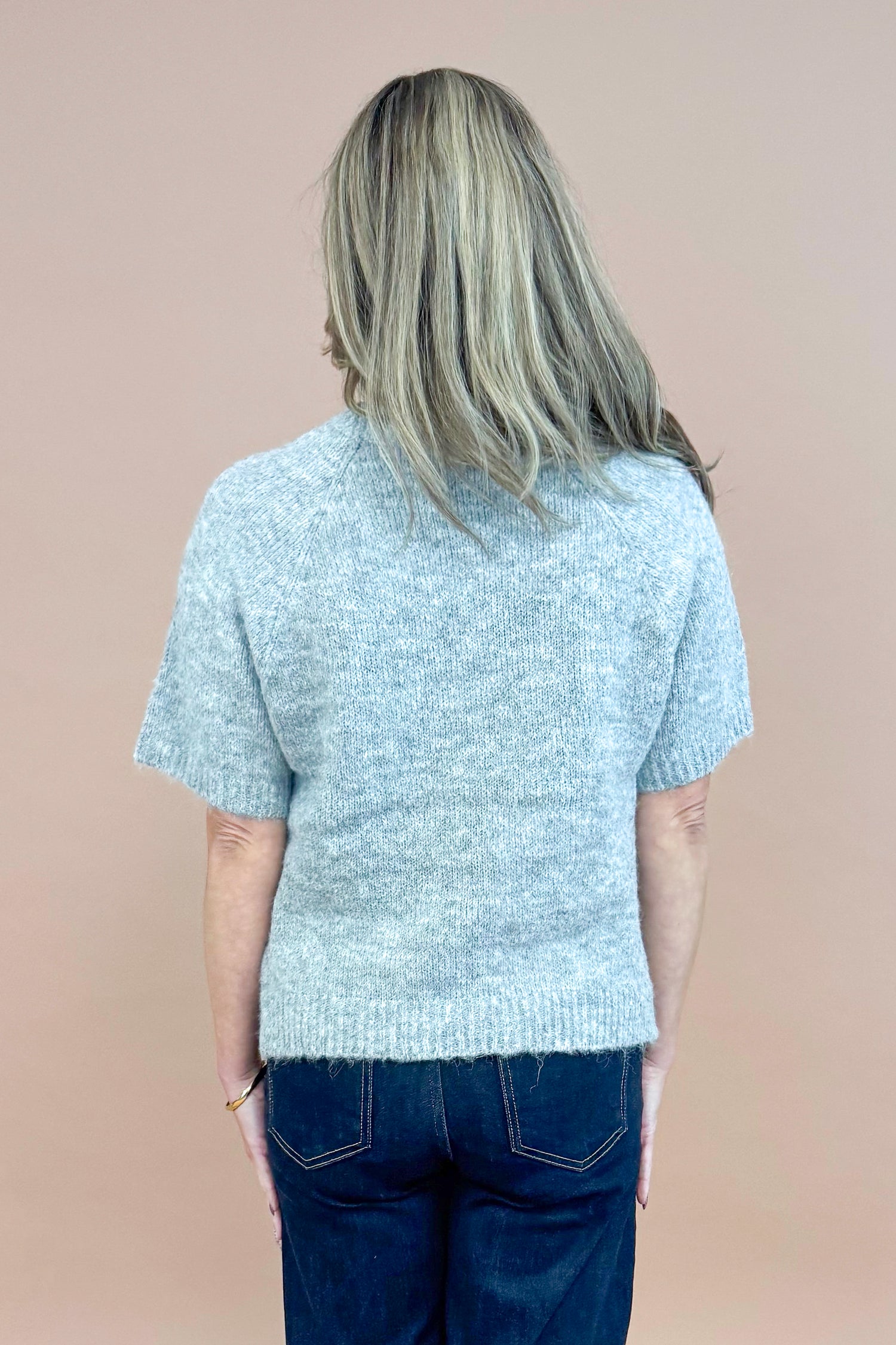 Back view of woman wearing Grey Floral &amp; Pearl Detail Short Sleeve Sweater by Entro and blue jeans. 