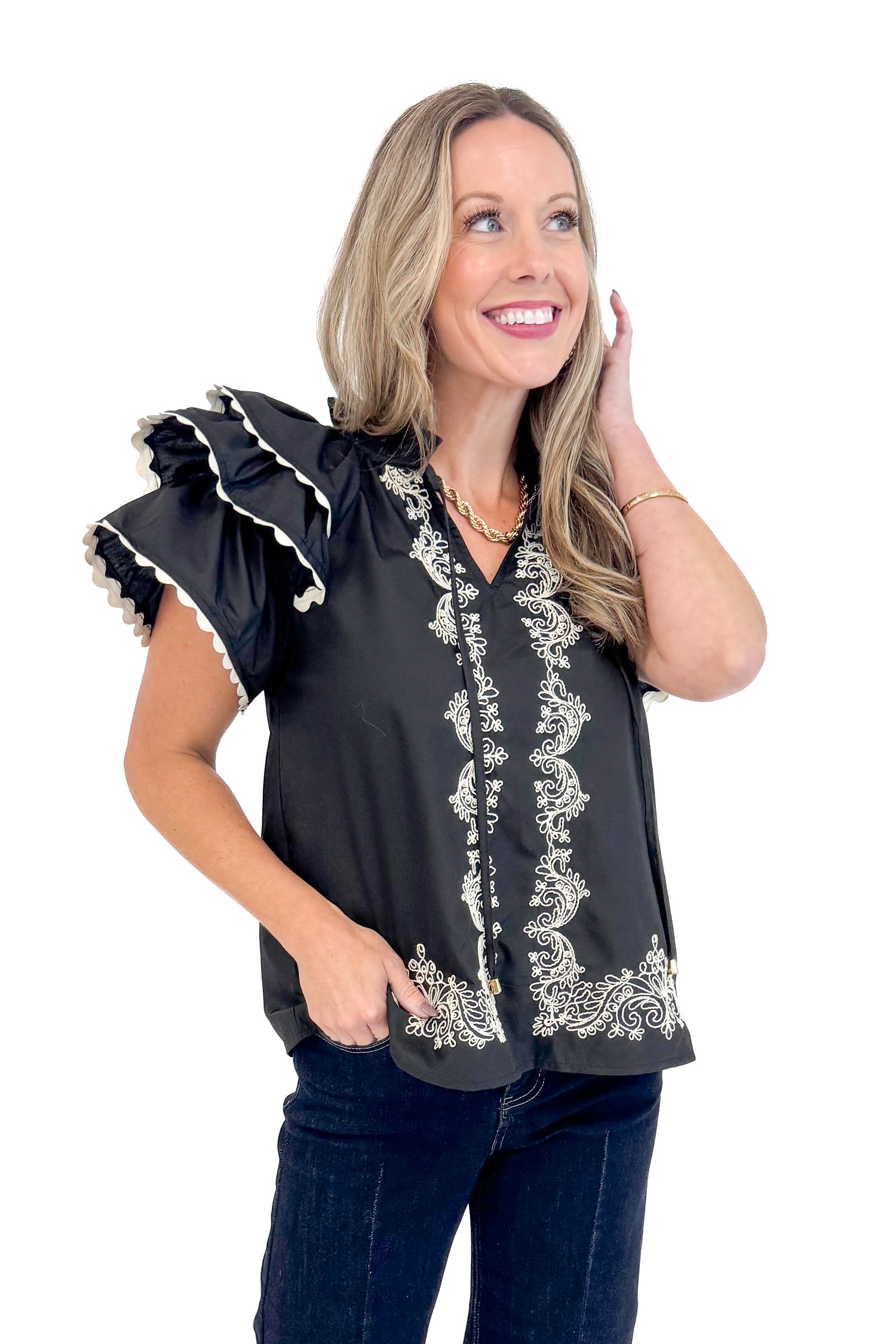 Front view of woman wearing Black Center Embroidered Ruffle Sleeve Top by Entro and blue jeans. 