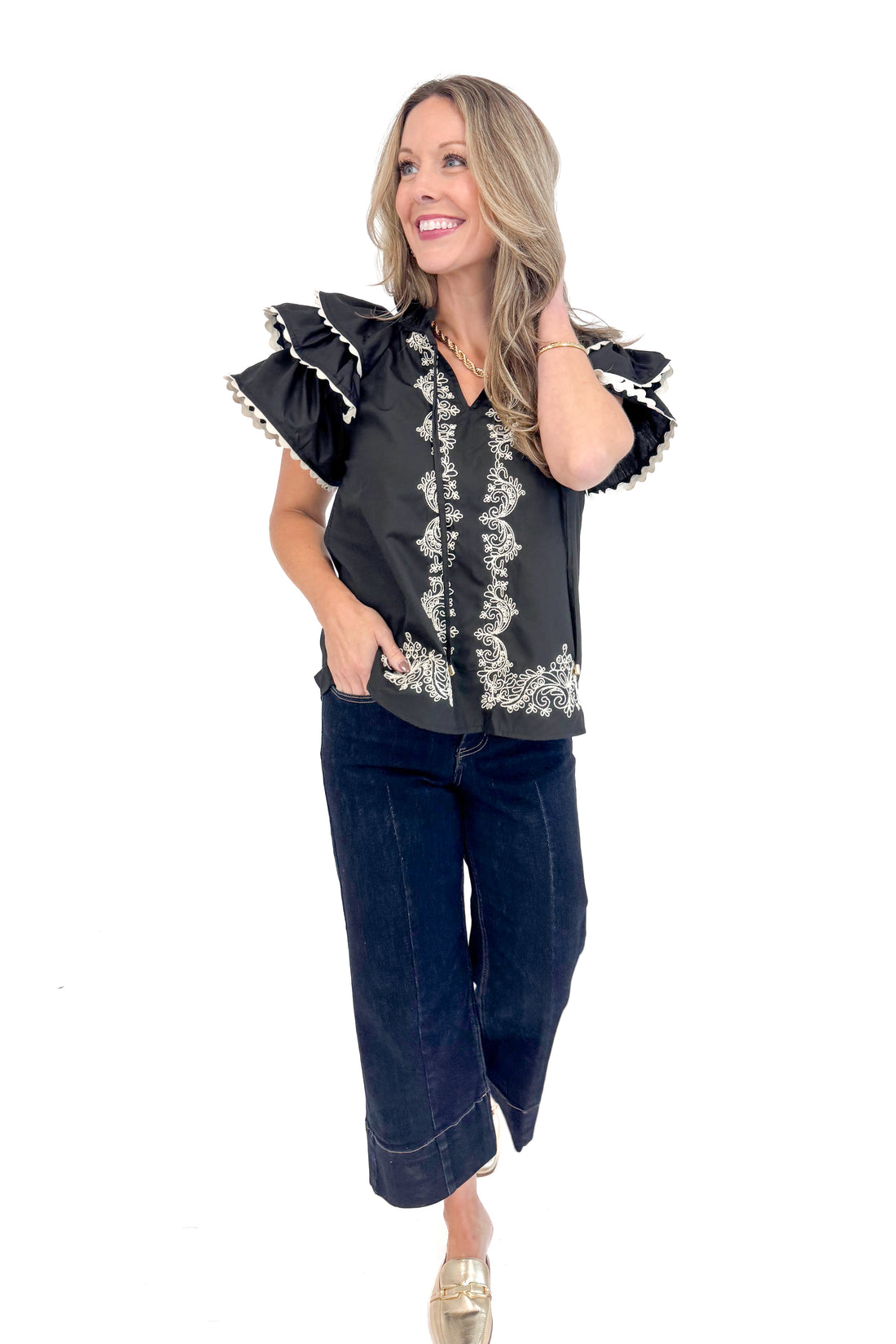 Front view of woman wearing Black Center Embroidered Ruffle Sleeve Top by Entro and blue jeans.