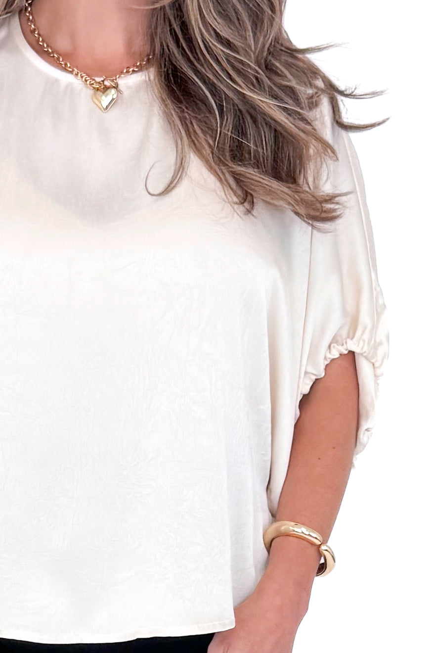 Front detailed view of woman wearing Champagne Satin Tie Sleeve Top with jeans against white studio background.