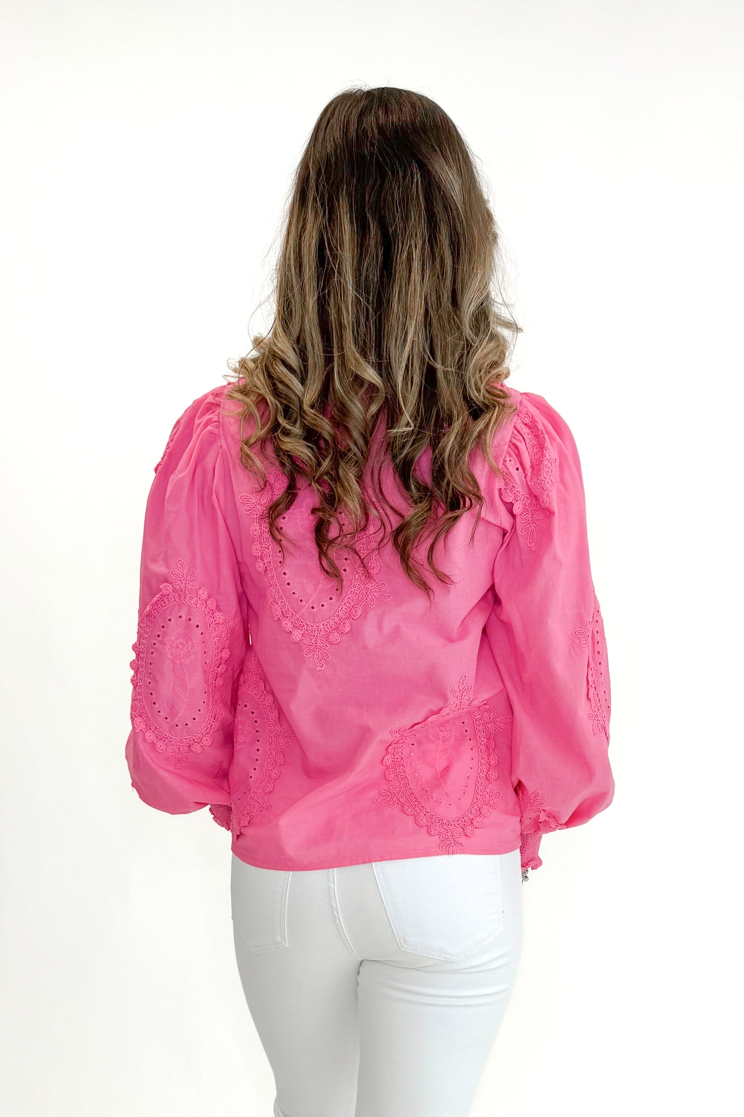 Back view of woman wearing Hot Pink Applique Button Up Top by Entro with jeans against white studio background.