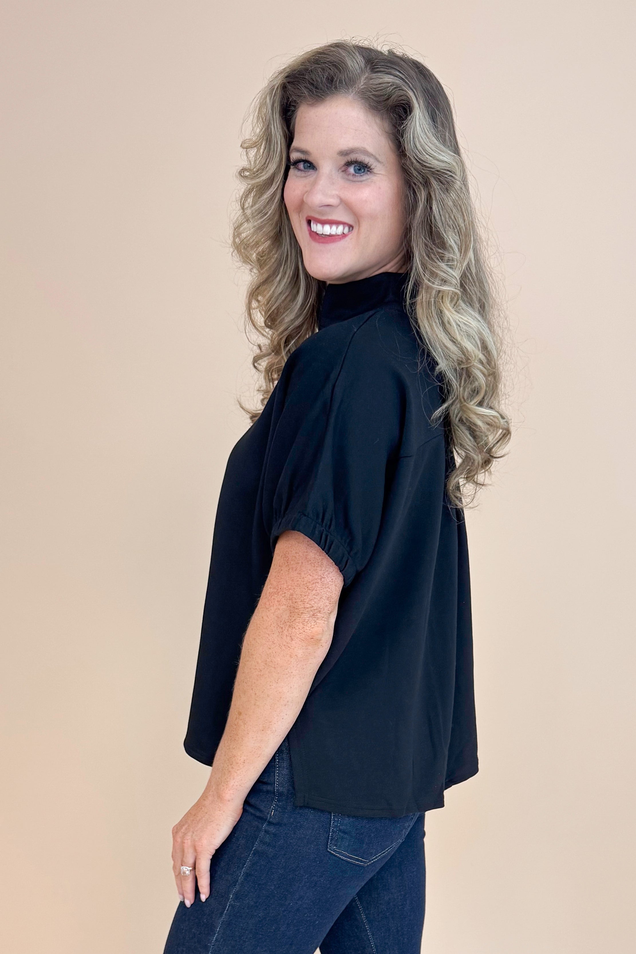 Side view of Black Collared V-neck Top by Entro and blue jeans. 