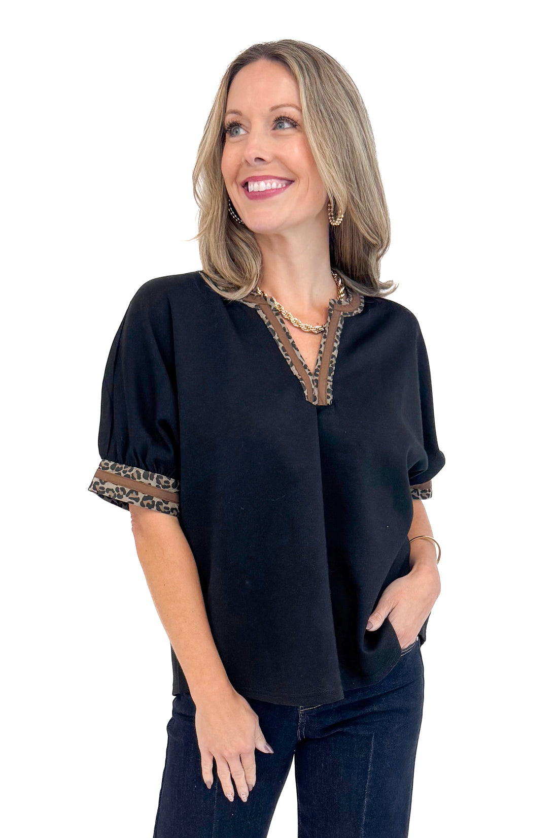 Front photo of woman wearing a Black Leopard Lined V-neck Top by Entro.