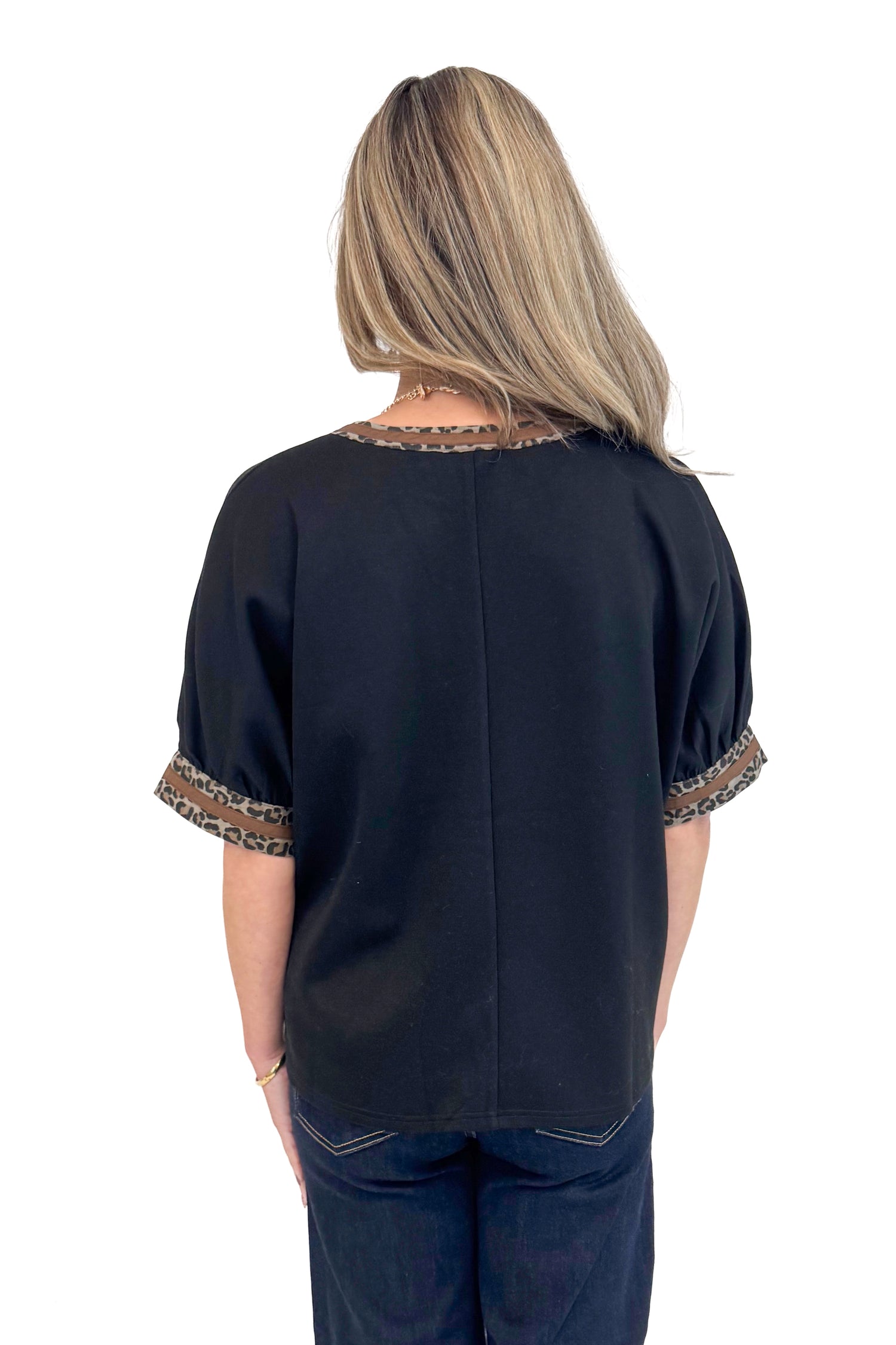 Back photo of woman wearing a Black Leopard Lined V-neck Top by Entro.