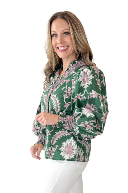 Side view of woman wearing Green &amp; Pink Printed Smocked Center Top with jeans against white studio background.