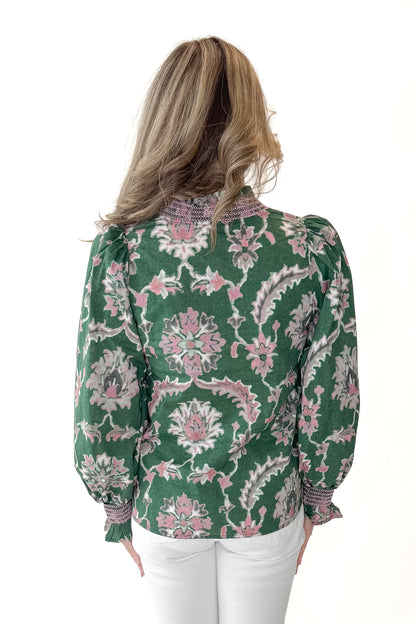 Back view of woman wearing Green &amp; Pink Printed Smocked Center Top with jeans against white studio background.