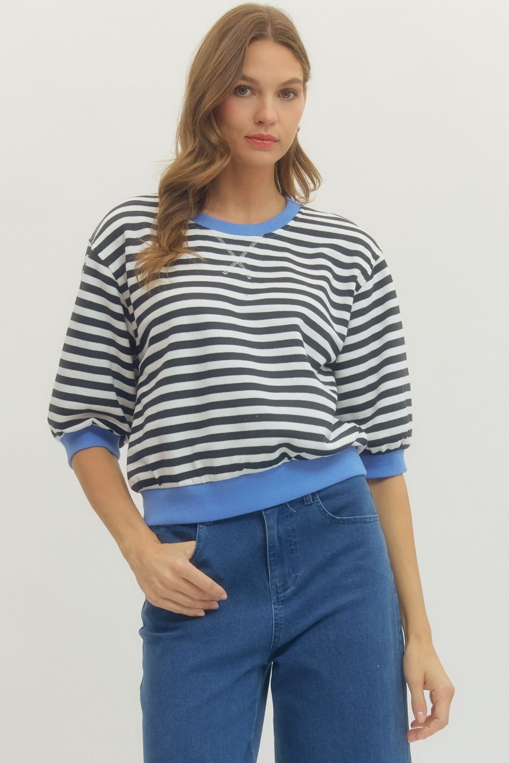 Front view of woman wearing Black Striped With Blue Lining 3/4 Sleeve Sweatshirt by Entro with jeans against a white background.