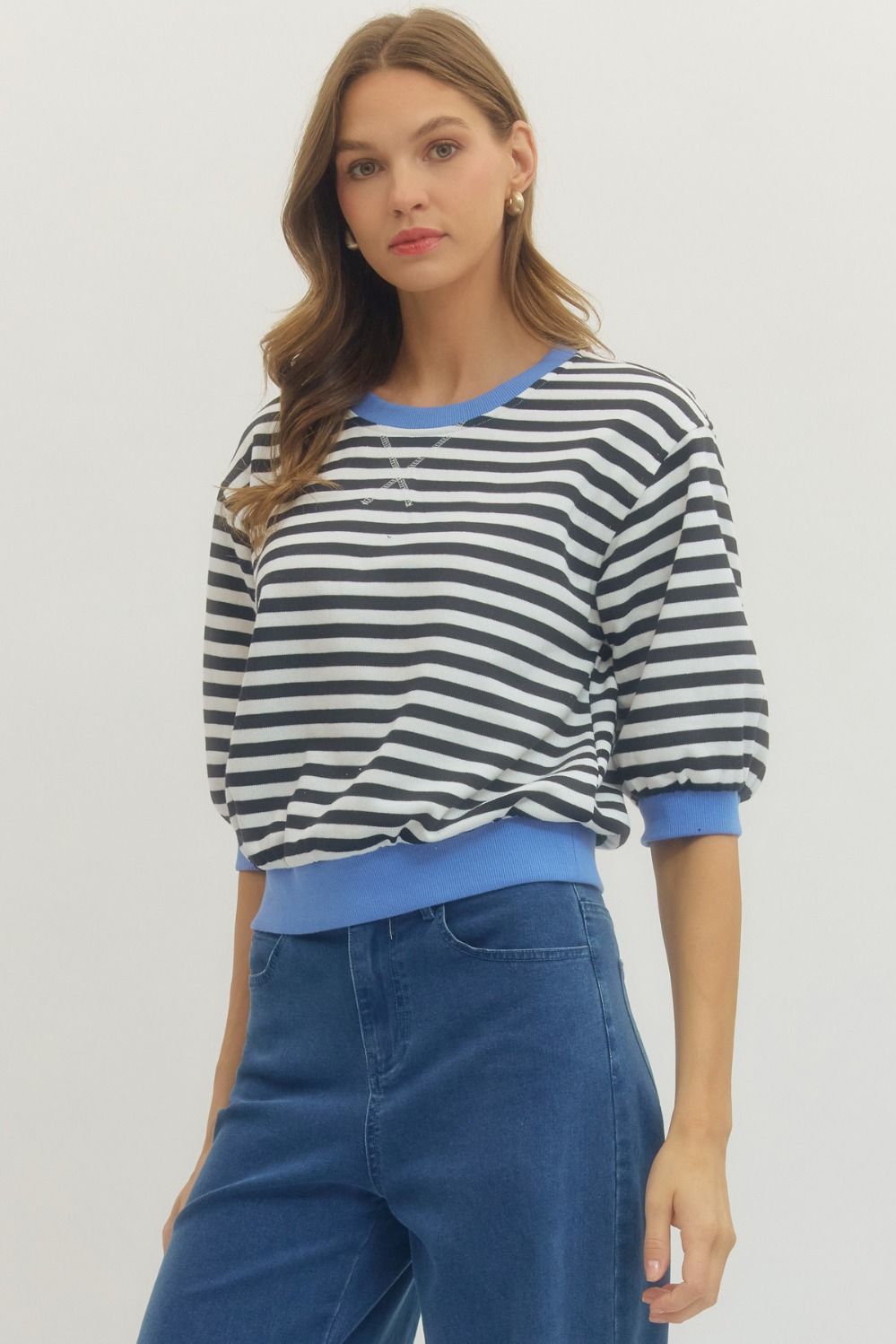 Front view of woman wearing Black Striped With Blue Lining 3/4 Sleeve Sweatshirt by Entro with jeans against a white background.