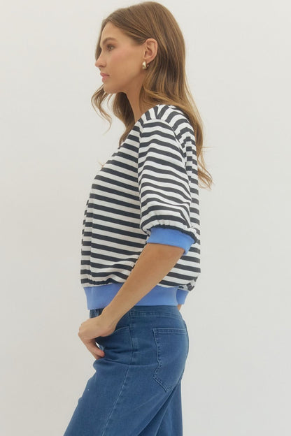 Side view of woman wearing Black Striped With Blue Lining 3/4 Sleeve Sweatshirt by Entro with jeans against a white background.