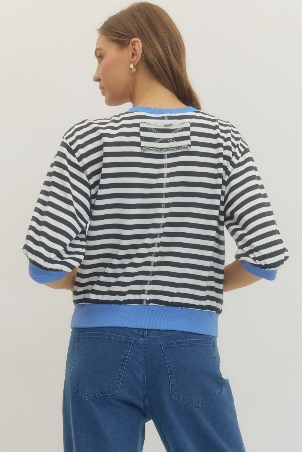Back view of woman wearing Black Striped With Blue Lining 3/4 Sleeve Sweatshirt by Entro with jeans against a white background.