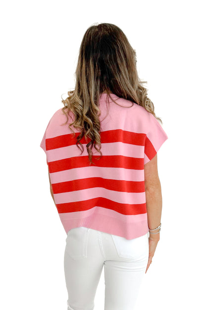 Back view of woman wearing Pink &amp; Red Sleeveless Sweater by Entro with jeans against white studio background.