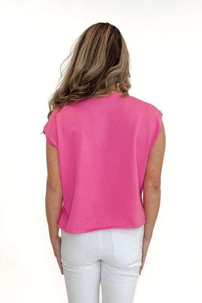Back view of woman wearing Pink Ribbed V-Neck Sleeveless Sweater by Entro with jeans against white studio background.