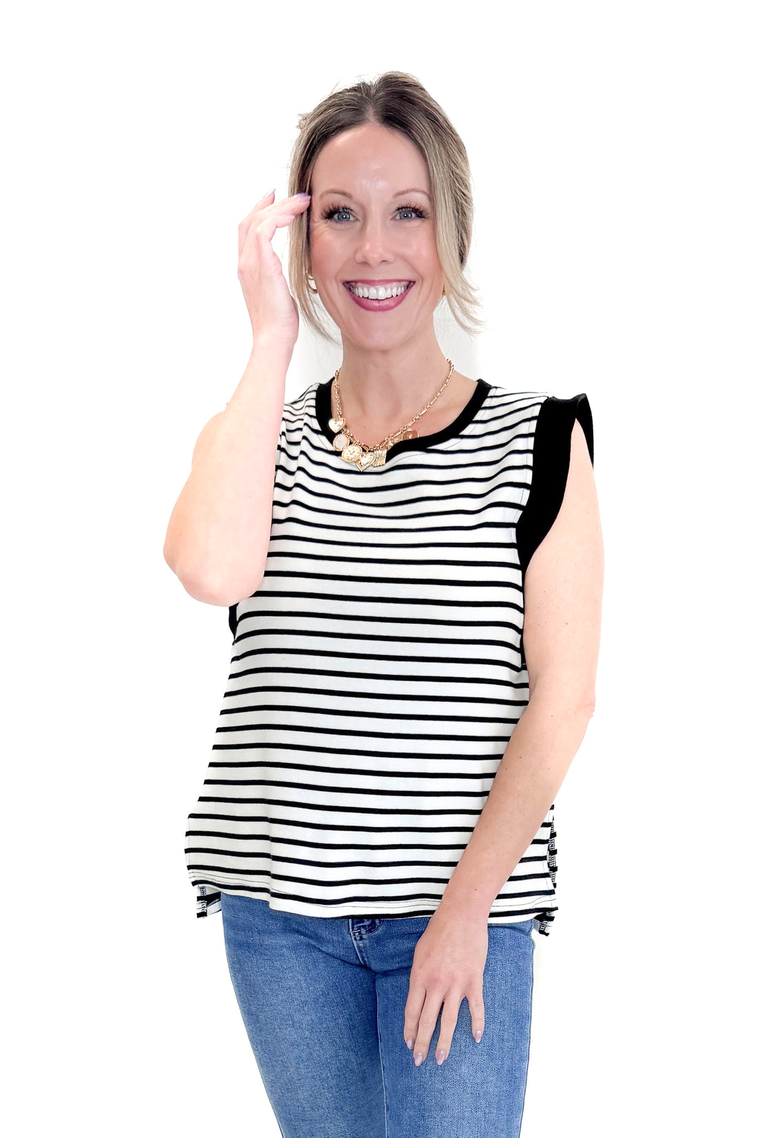 Front view of woman wearing White &amp; Black Striped Sleeveless Top by Entro with jeans against white studio background.