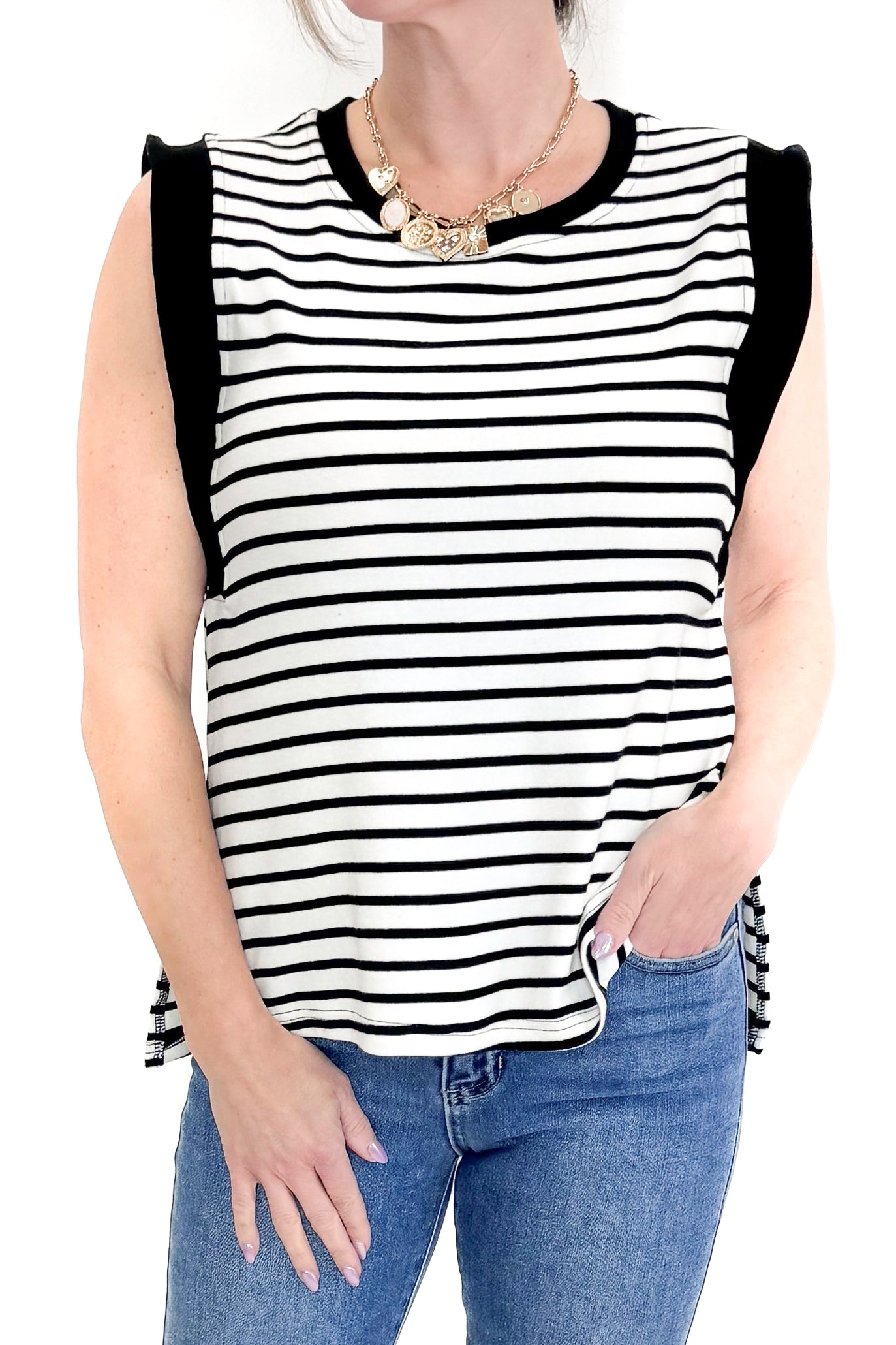Front detail view of woman wearing White &amp; Black Striped Sleeveless Top by Entro with jeans against white studio background.