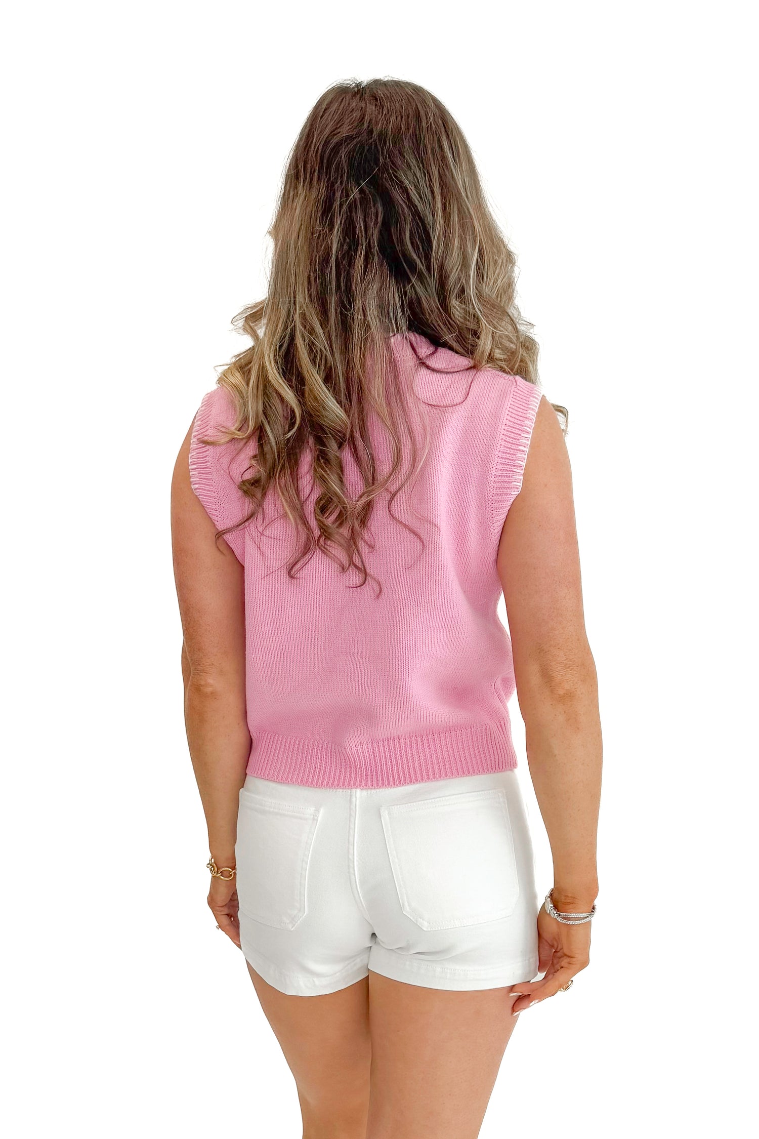 Back view of woman wearing Light Pink Sardine Sweater Tank by Entro with jean shorts against white studio background.