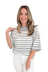 Front view of woman wearing Light Blue & Navy Striped Top by Entro with jeans against white studio background.